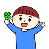 四葉のクローバーを見つけて喜ぶ男の子