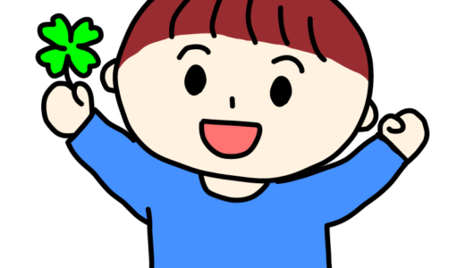 四葉のクローバーを見つけて喜ぶ男の子